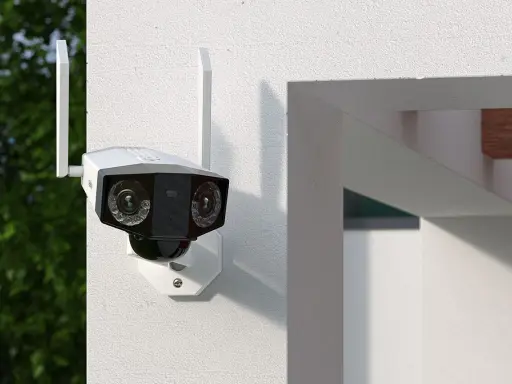 Kamera monitoringu z dwoma obiektywami zamontowana na białej ścianie.